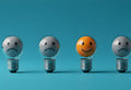 Four light bulbs, three with sad faces and one with a smiling face
