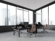 SPEND 08 installed in modern office space with three black desks, computer monitors, and beige office chairs in front of large windows with a city view.